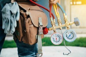 air conditioning technician with tool belt and equipment