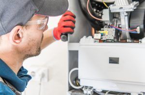 A technician repairs a heating system. Call our 24/7 repair team if you have a heating or furnace emergency in Las Vegas, NV.