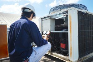 technician checks facility’s ac unit