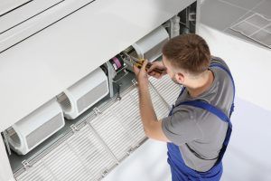 technician repairs hospital’s ac unit