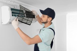air conditioner technician replaces ac filter