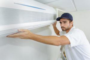 technician installs replacement AC unit