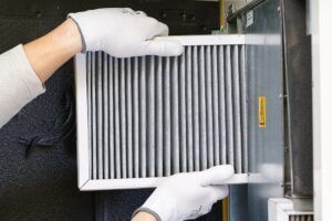 tech sliding new AC filter into unit